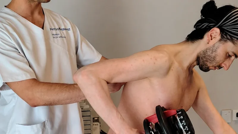 Daniel supervisa a un paciente haciendo remo unilateral en Infinitum Corpore Bilbao